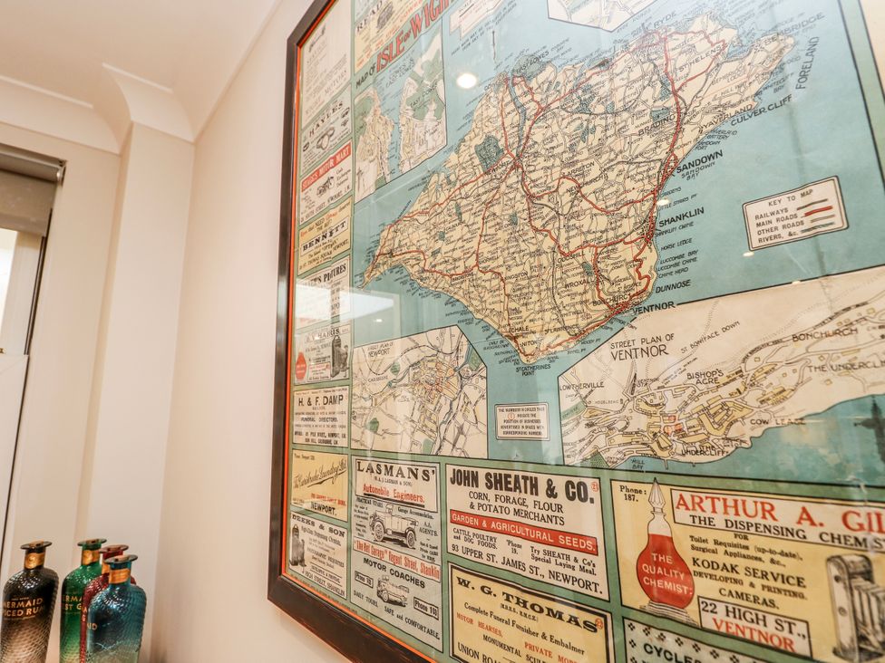 A framed map of the Isle of Wight with vintage advertisements at 6 Priory Shanklin