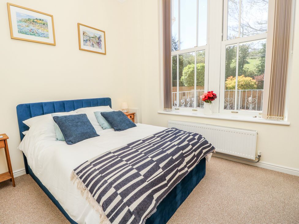 A bedroom with a bed and windows at 6 Priory in Shanklin