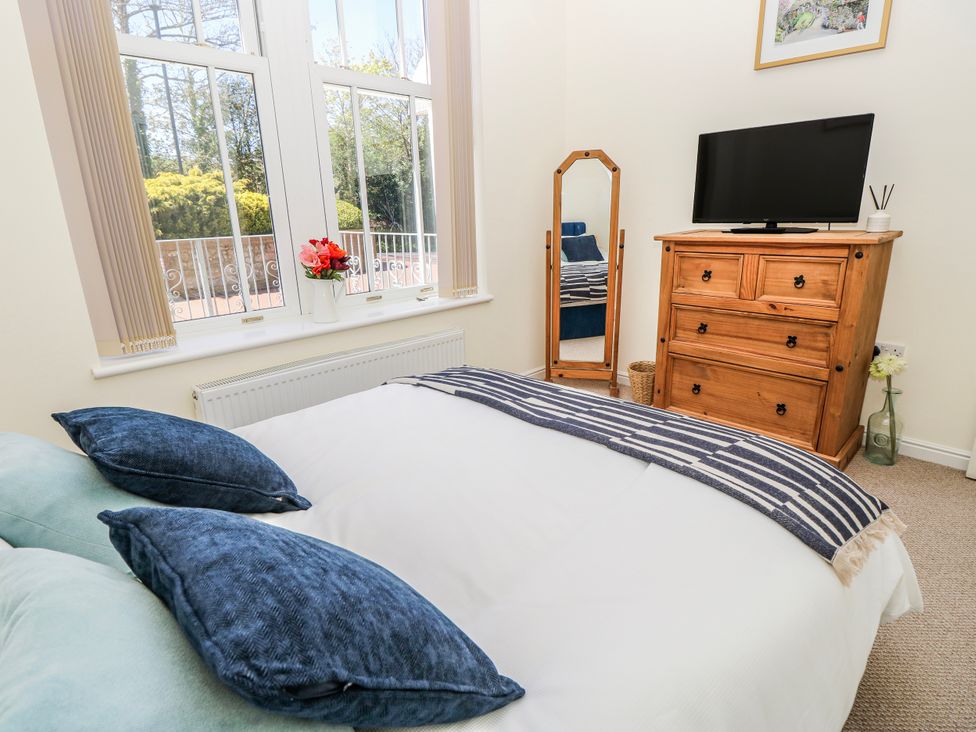 A bedroom with a bed and television at 6 Priory in Shanklin