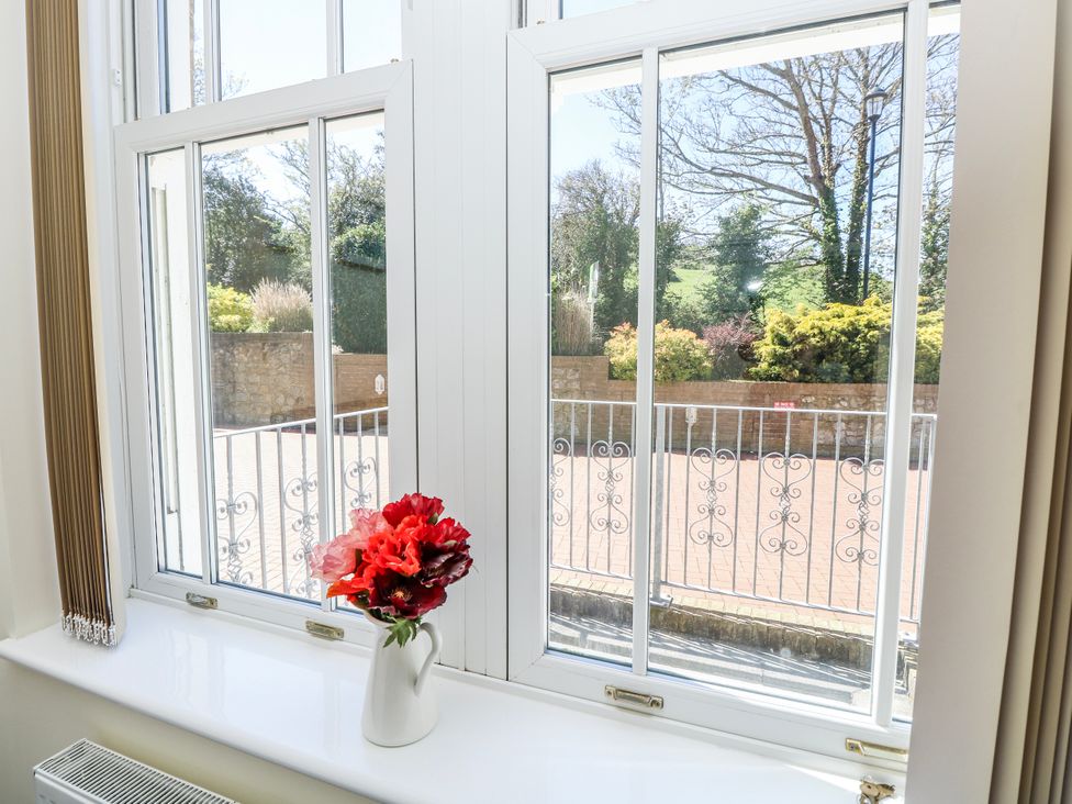 A window with a flower vase overlooking a garden at 6 Priory in Shanklin