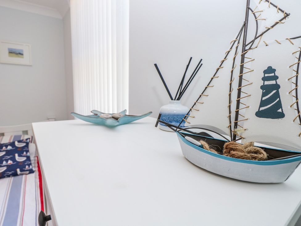 A decorative setup with a sailboat and vase at 6 Priory in Shanklin