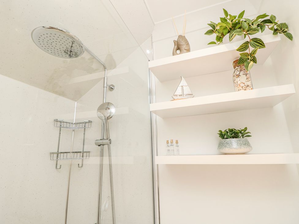A shower with a shelf featuring decor at 6 Priory in Shanklin