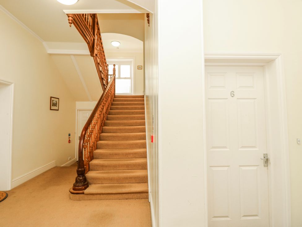 A hallway with a staircase and a door at 6 Priory Shanklin