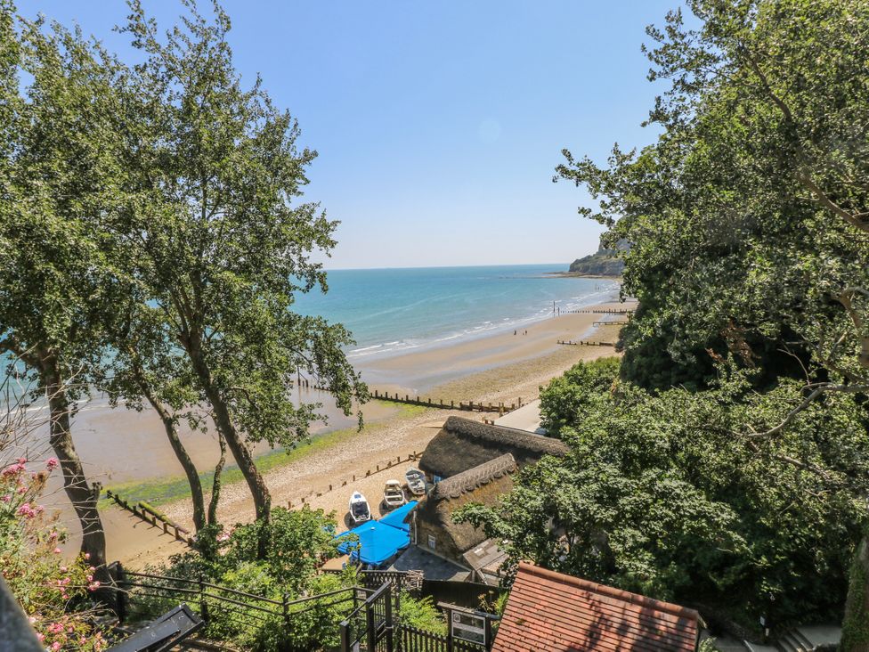 A beach with boats and trees at 6 Priory in Shanklin