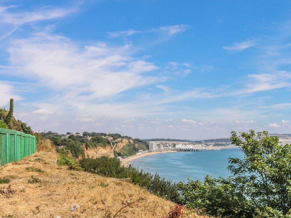 A beach view with a fence and cliffs at 6 Priory in Shanklin