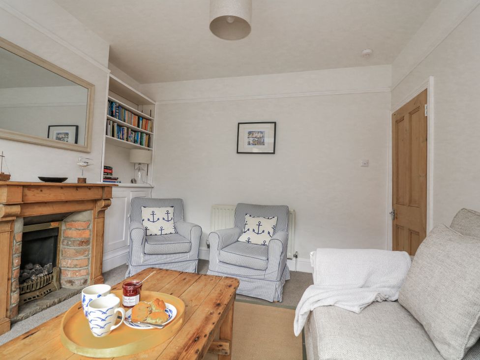 A living room with a fireplace and seating area at Shipwrights in Salcombe