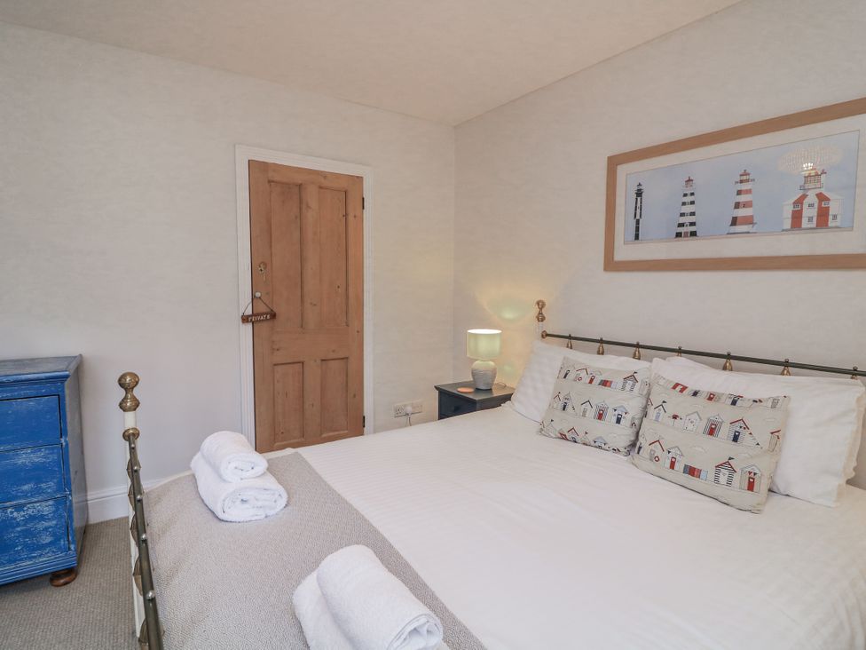 A bedroom featuring a bed, pillows, and a lamp at Shipwrights in Salcombe