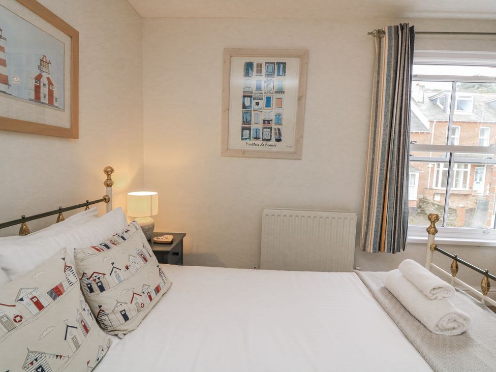 A bedroom with a bed and artwork at Shipwrights in Salcombe