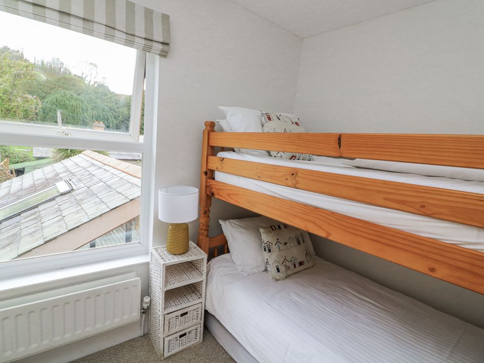A bedroom with a bunk bed and a lamp at Shipwrights in Salcombe