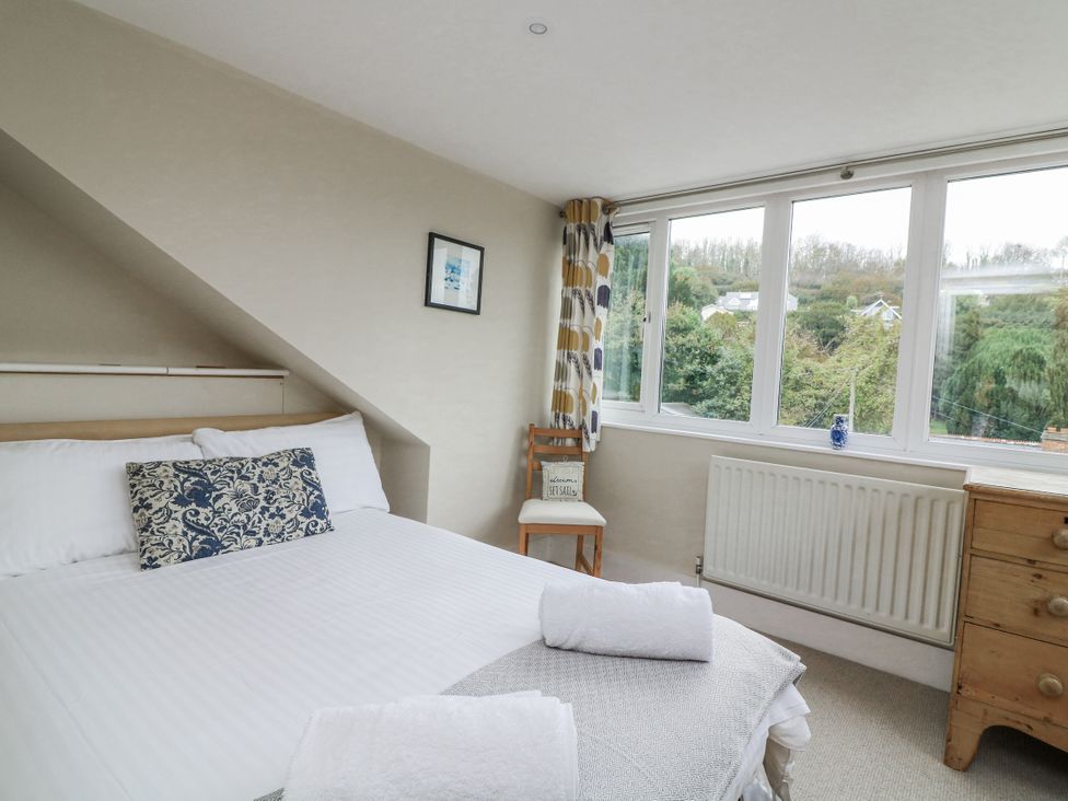 A bedroom with a bed and window at Shipwrights in Salcombe