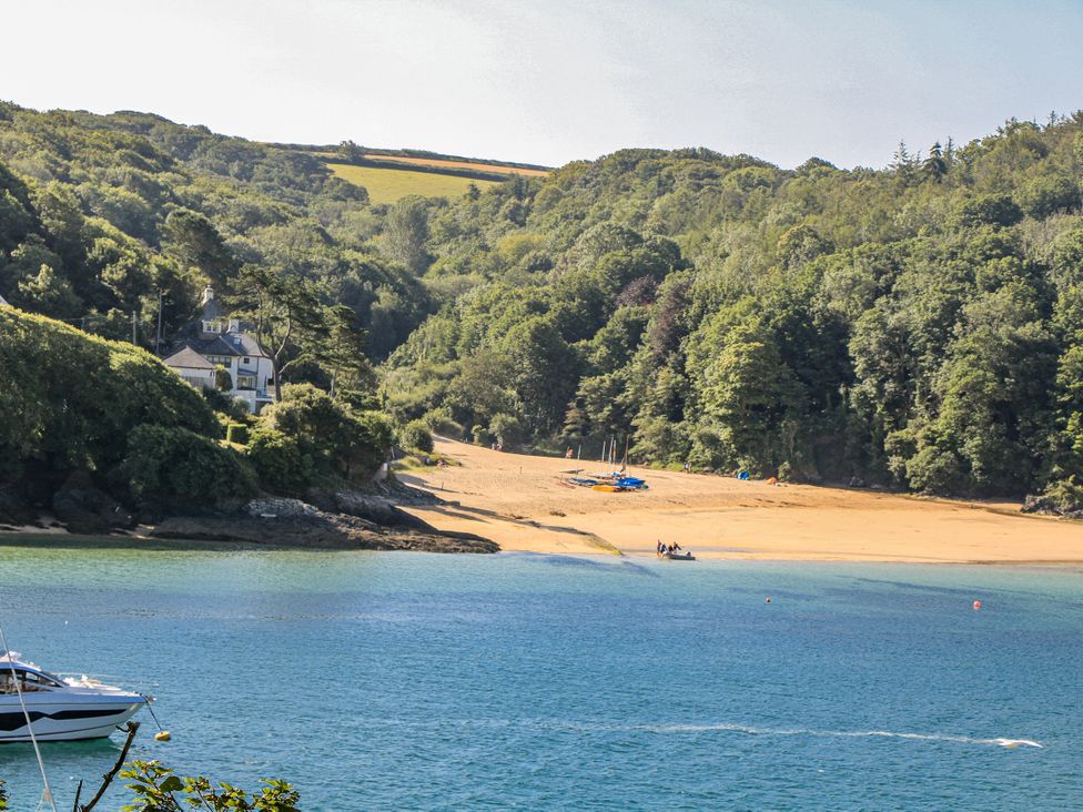 A beach with a house and trees at Shipwrights in Salcombe