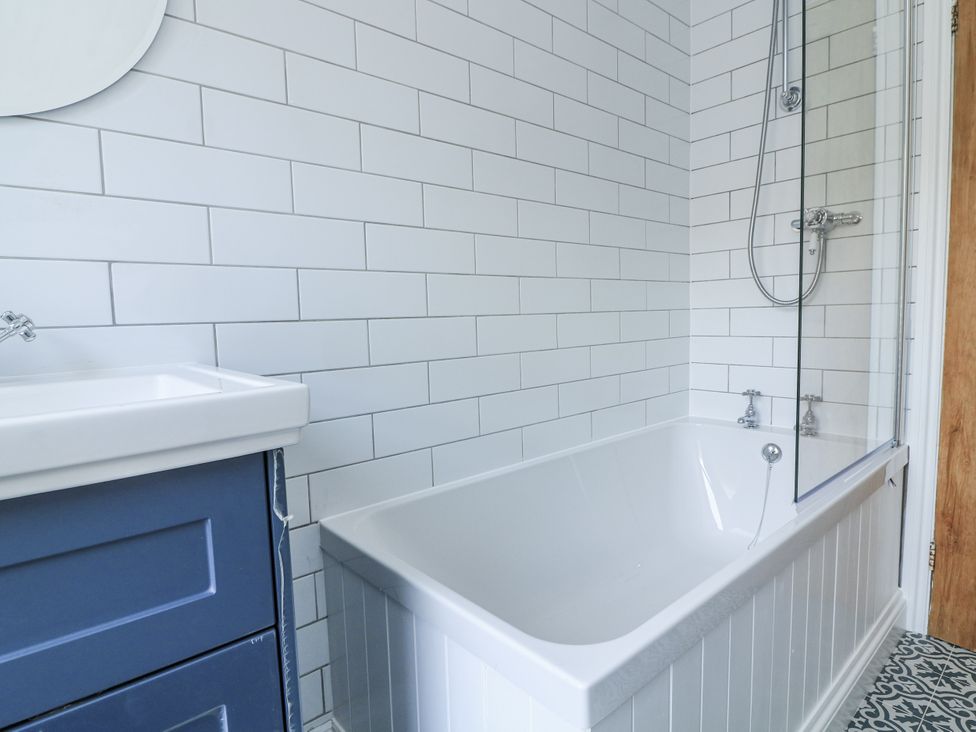 A bathroom with a bathtub and sink at Shipwrights Coronation Road in Salcombe