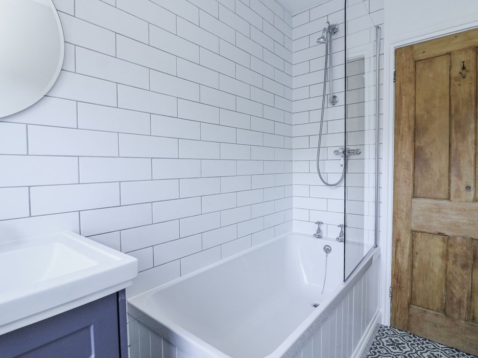 A bathroom with a bathtub and a shower at Shipwrights 11 Coronation Road Salcombe