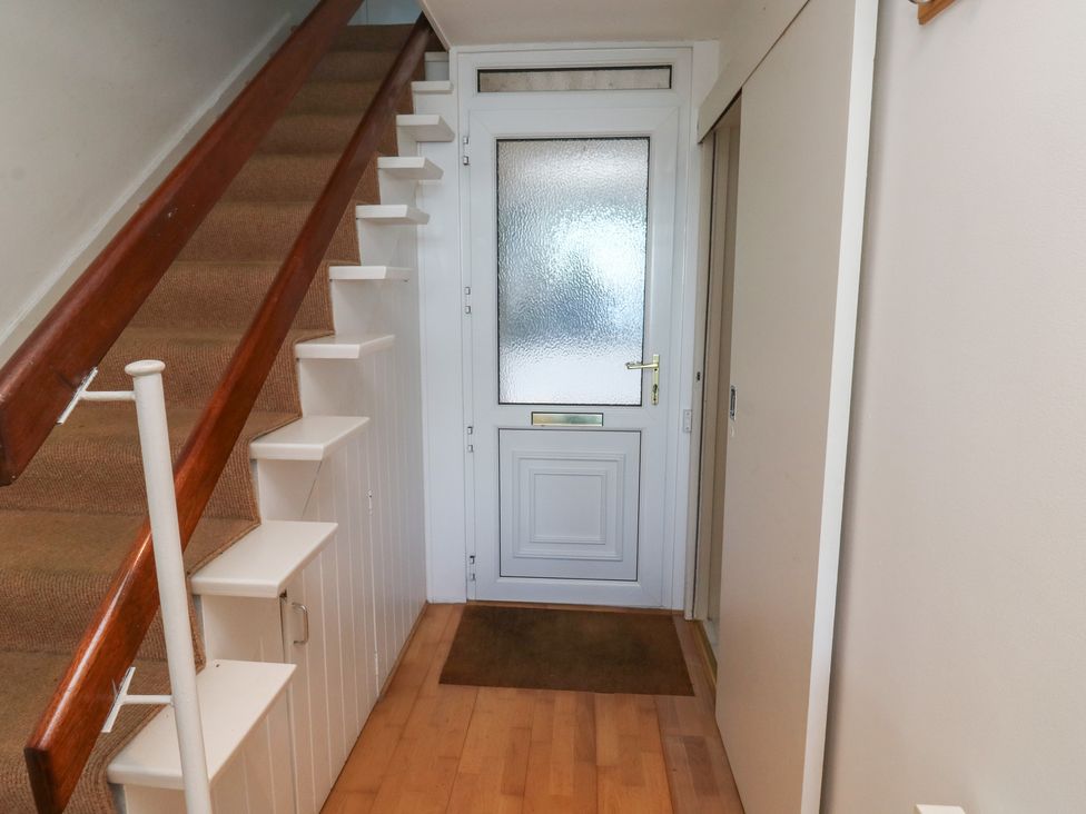 A hallway with stairs and a front door at 20 Heath Court in Brixham