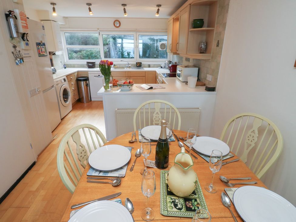 A kitchen with dining table and utensils at 20 Heath Court in Brixham