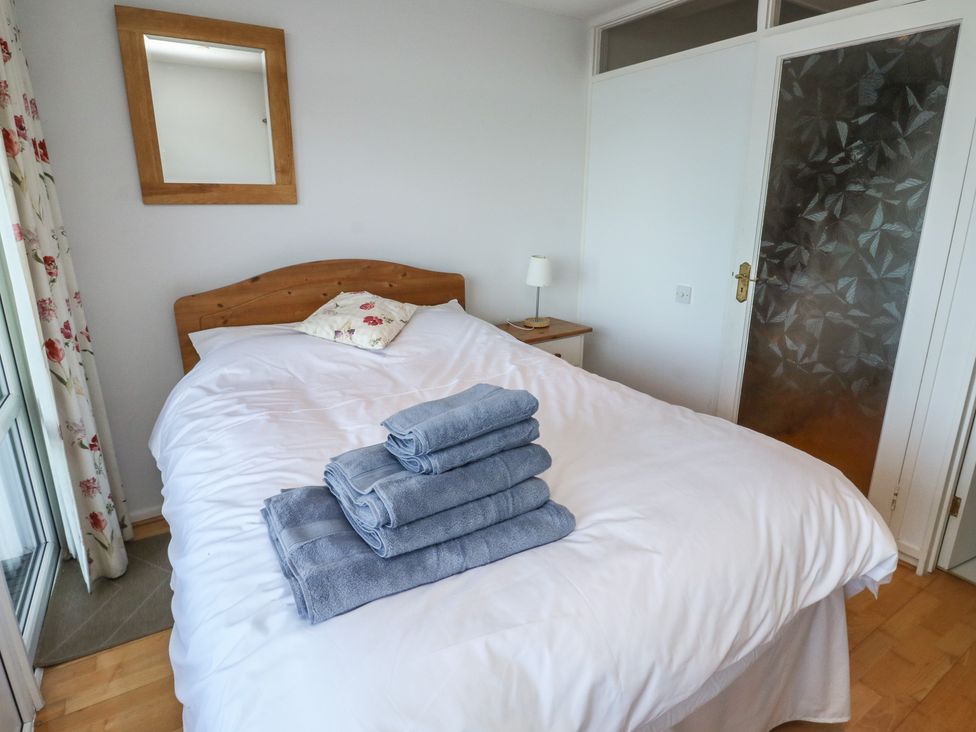 A bedroom with a bed and towels on the bed at 20 Heath Court in Brixham