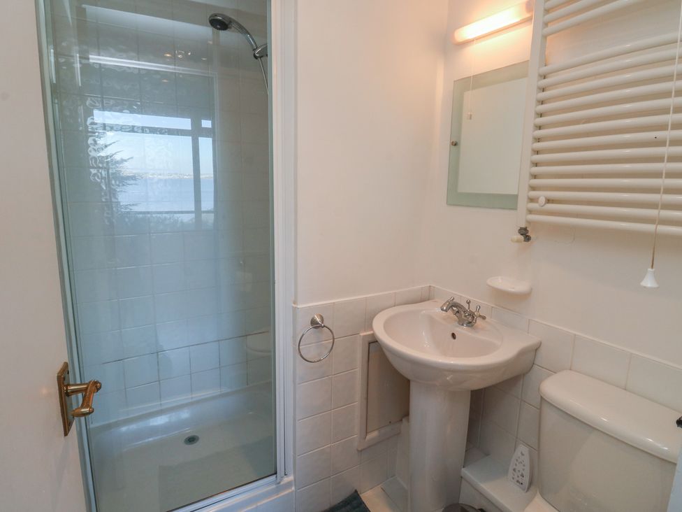 A bathroom with a shower, toilet, and sink at 20 Heath Court in Brixham
