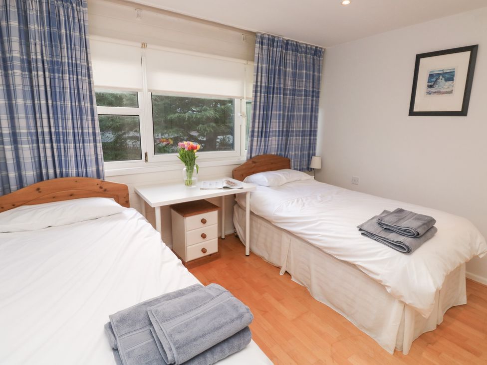 A bedroom with two beds and a desk at 20 Heath Court in Brixham