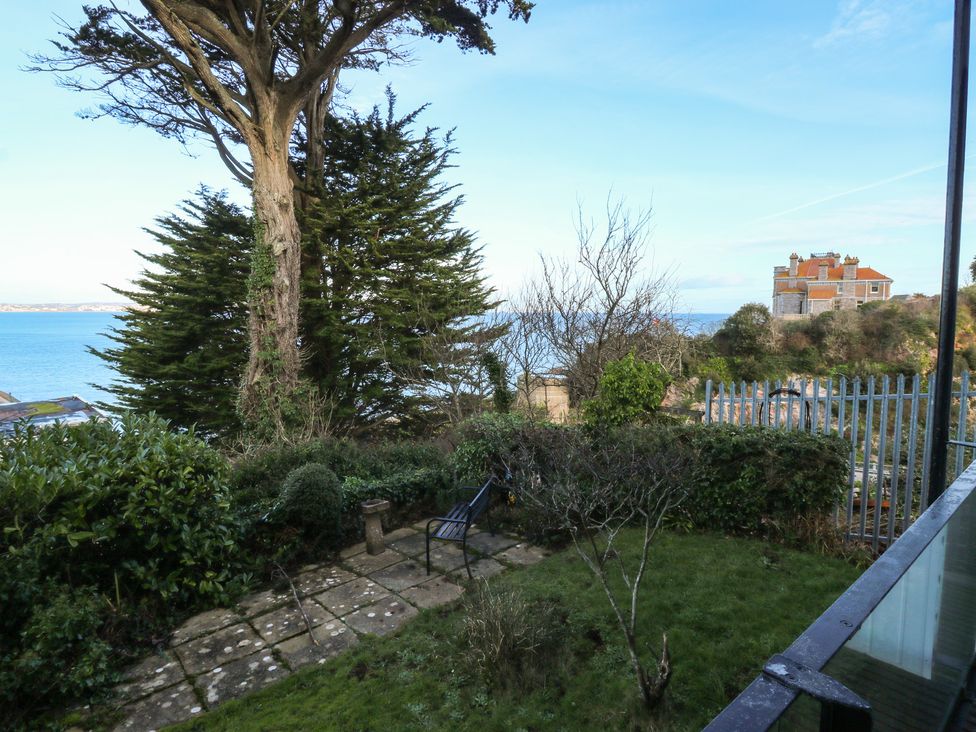 A garden with trees and sea view at 20 Heath Court in Brixham
