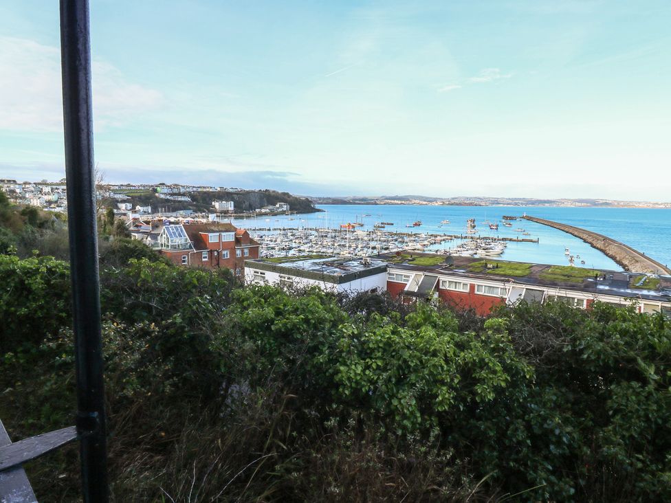 A view of a harbor with boats and buildings at 20 Heath Court in Brixham