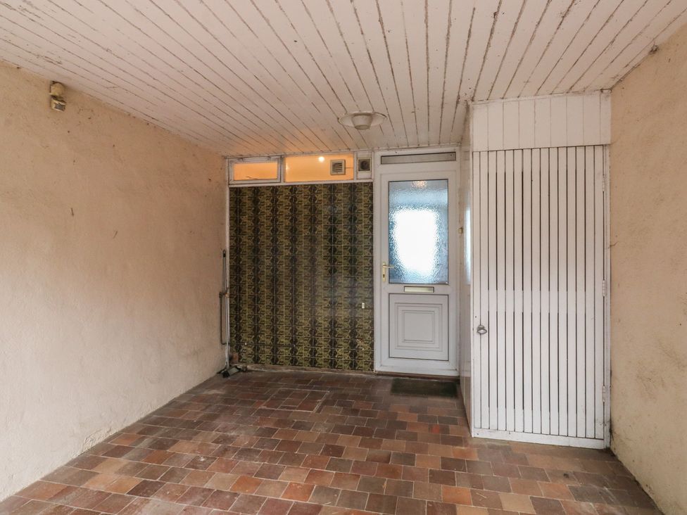 An entrance area with a tiled floor and a door at 20 Heath Court in Brixham