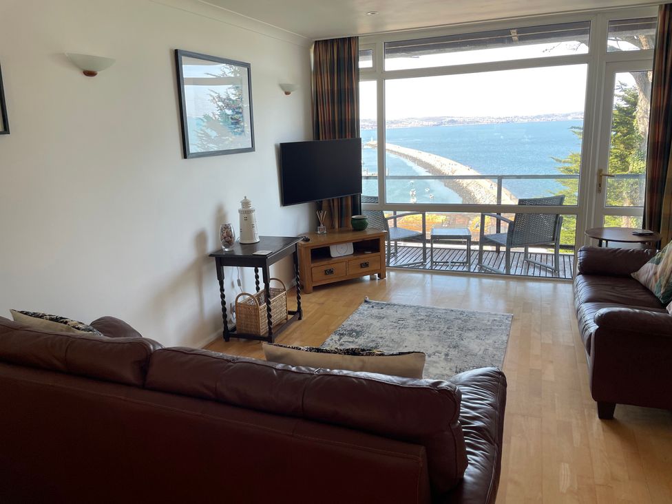 A living room with a television and seating area at Snowy Owl View at The Breakwater Brixham