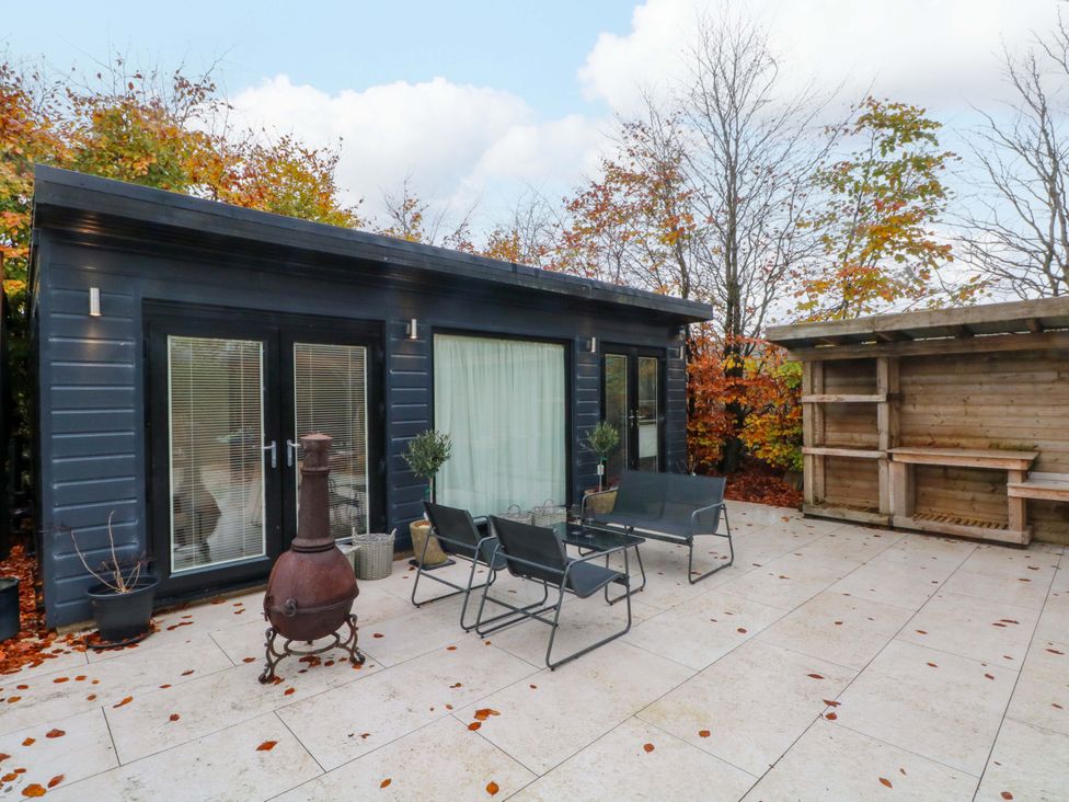 An outdoor patio with seating and wooden structure at Cabin