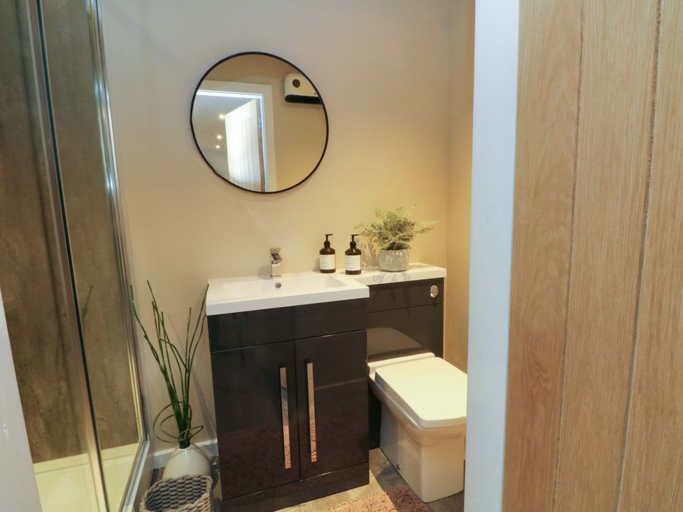 A bathroom with sink, toilet, and shower at Cabin in 