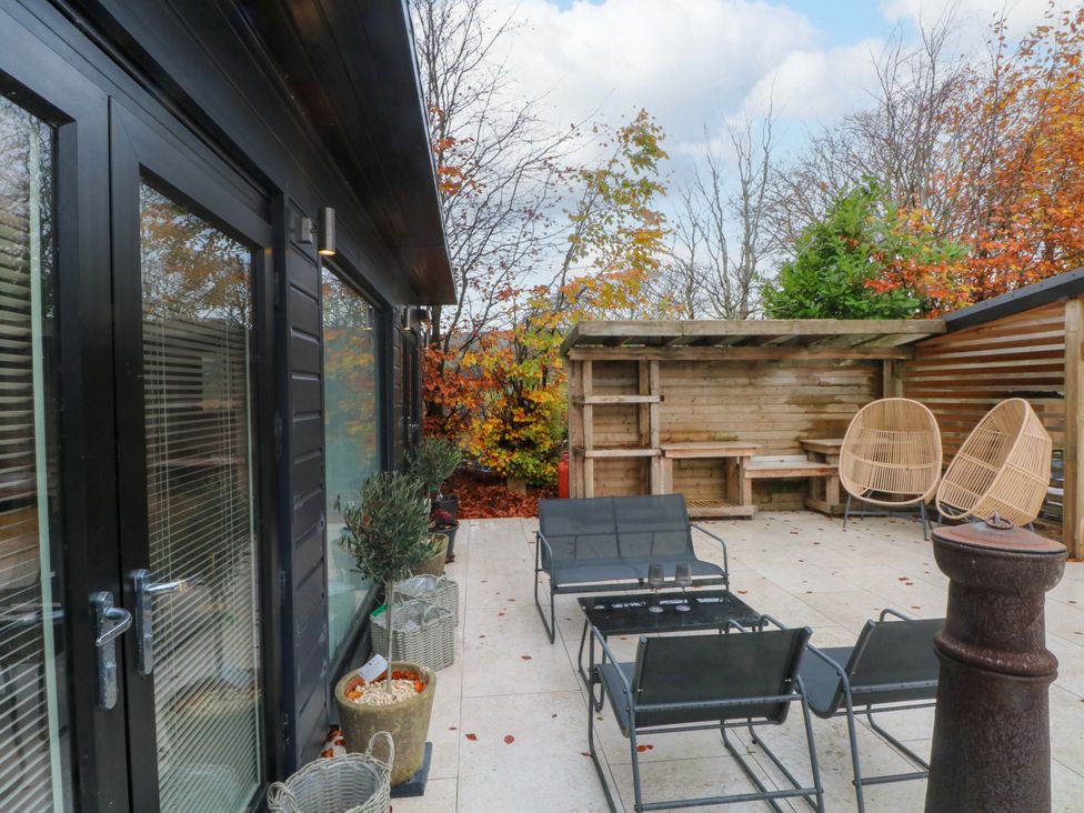 An outdoor patio area with seating and a wooden structure at Cabin 