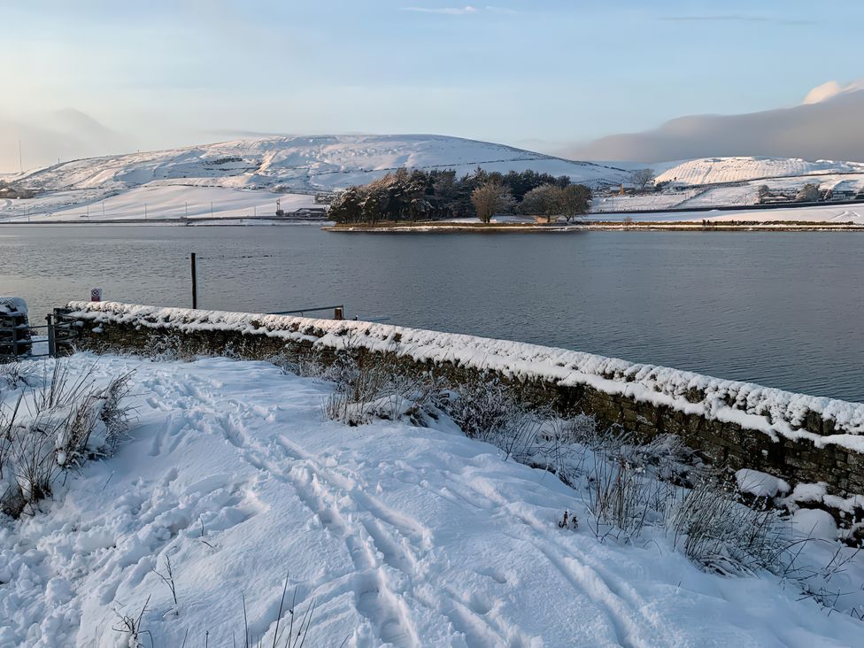 A snowy landscape with water and hills at The Cabin in Crawshawbooth