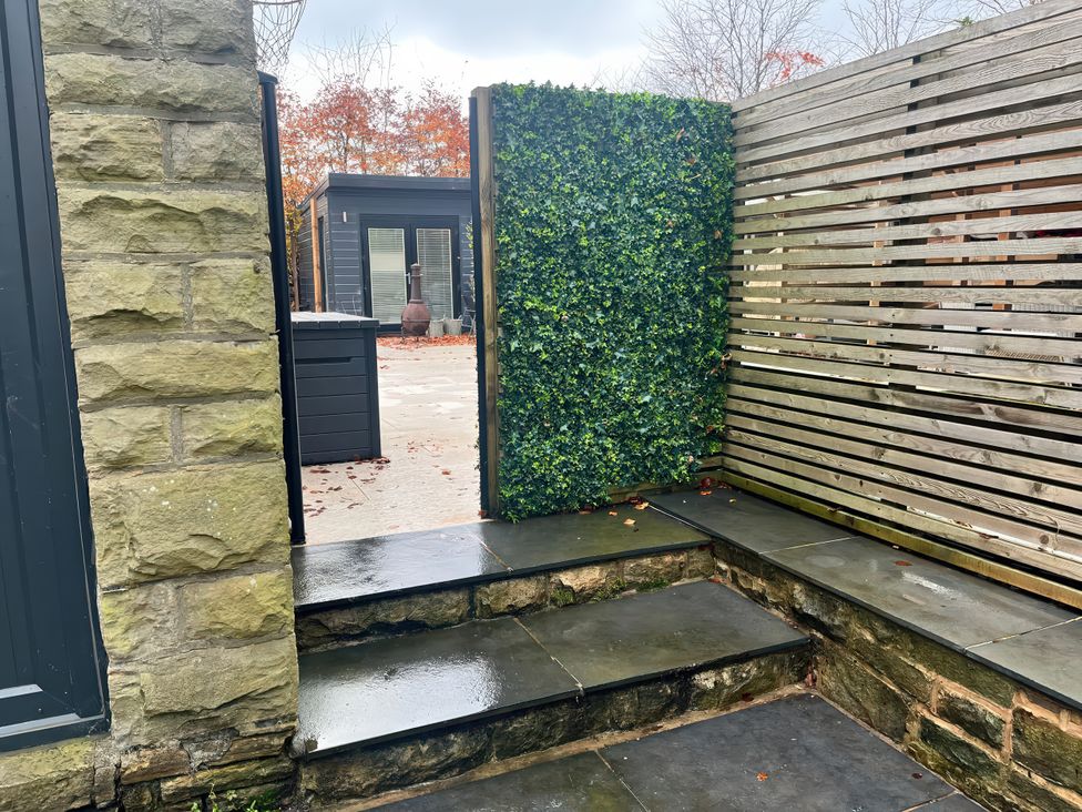 A garden with stone wall and steps at The Cabin in Loveclough near Crawshawbooth