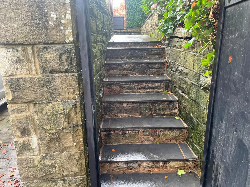 A staircase leading up with stone walls and gate at The Cabin in Loveclough near Crawshawbooth
