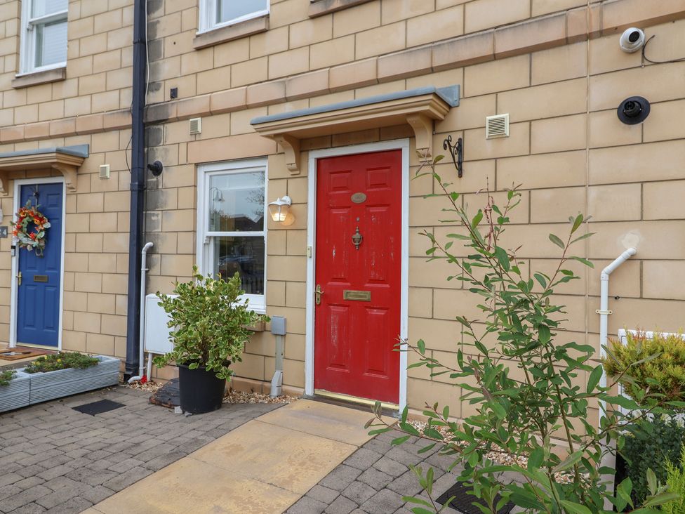 A red door with a blue door and plants at 122 Longridge Way Weston-Super-Mare