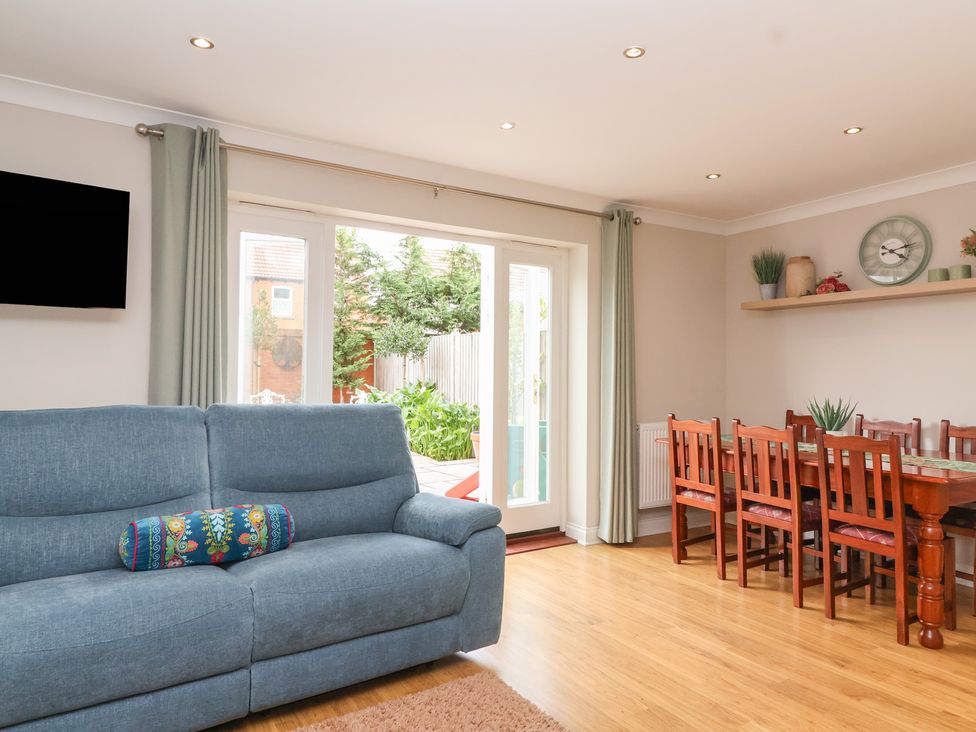 A dining room with a sofa and table at 122 Longridge Way Weston-Super-Mare