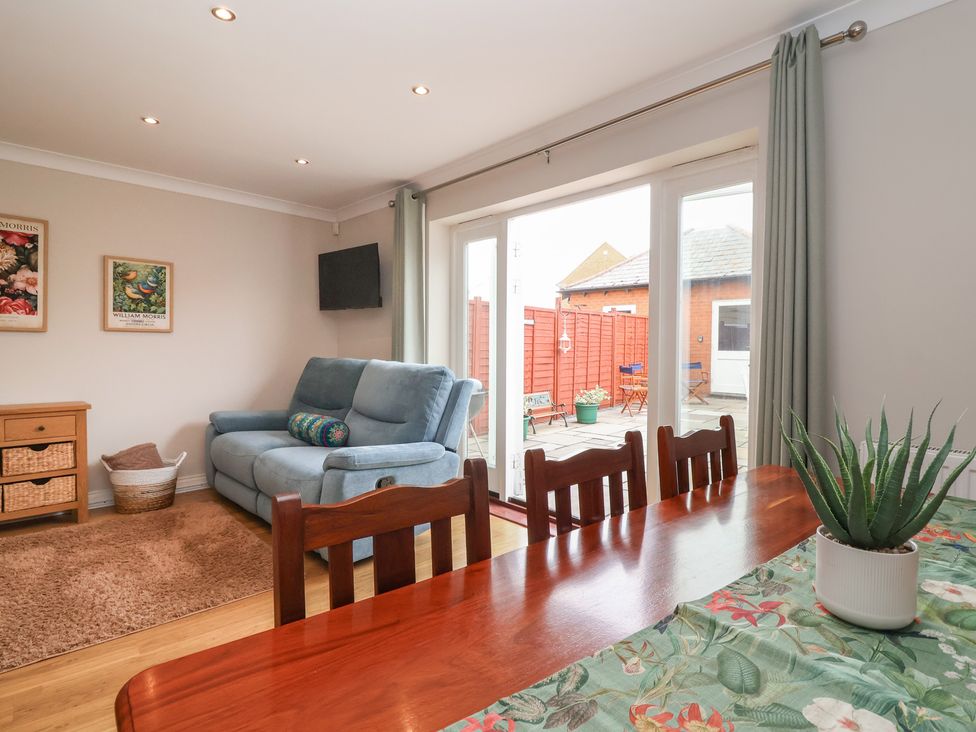 A dining room with a table and chairs next to a sofa at 122 Longridge Way Weston-Super-Mare