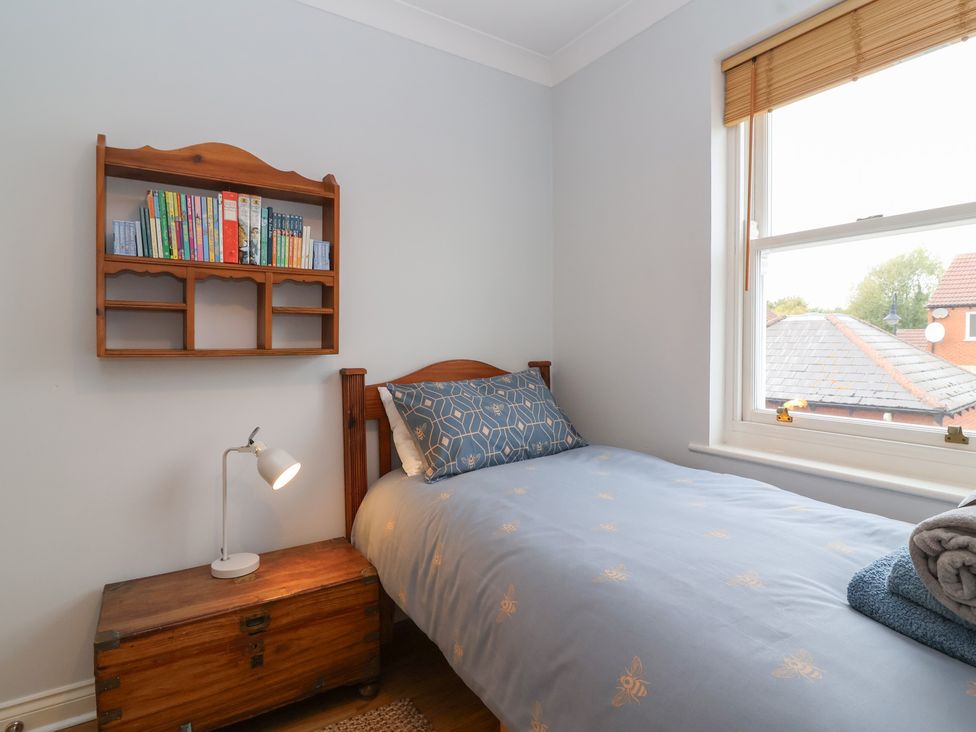 A bedroom with a bed and bookshelf at 122 Longridge Way Weston-Super-Mare