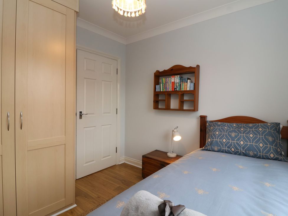 A bedroom with a bed and bookshelf at 122 Longridge Way Weston-Super-Mare