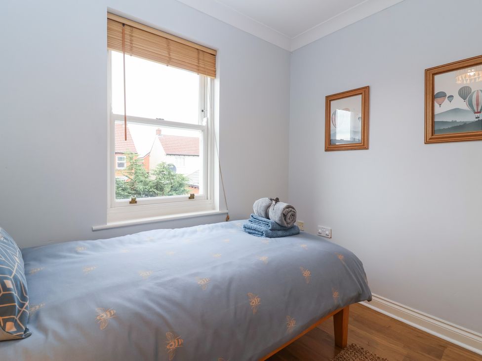 A bedroom with a bed and decorative pictures at 122 Longridge Way Weston-Super-Mare