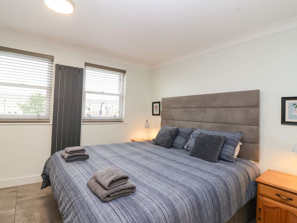 A bedroom with a large bed and bedside tables at 122 Longridge Way Weston-Super-Mare