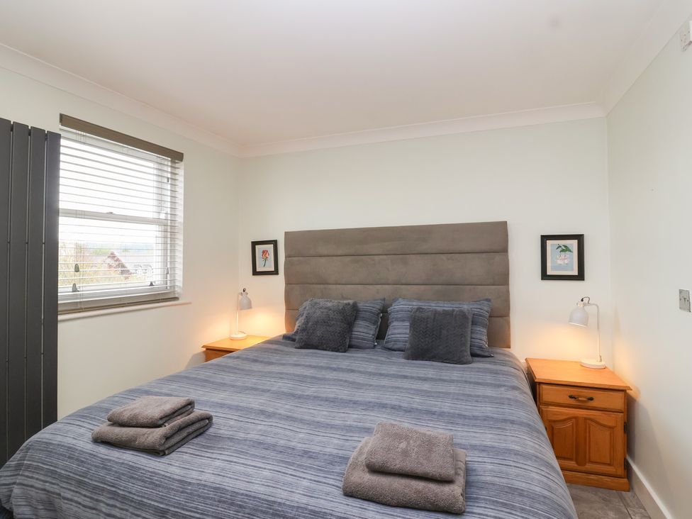 A bedroom with a bed and nightstands at 122 Longridge Way Weston-Super-Mare