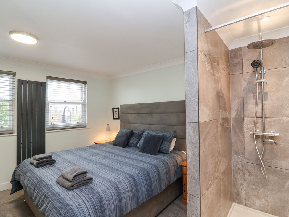 A bedroom with a bed and shower area at 122 Longridge Way Weston-Super-Mare