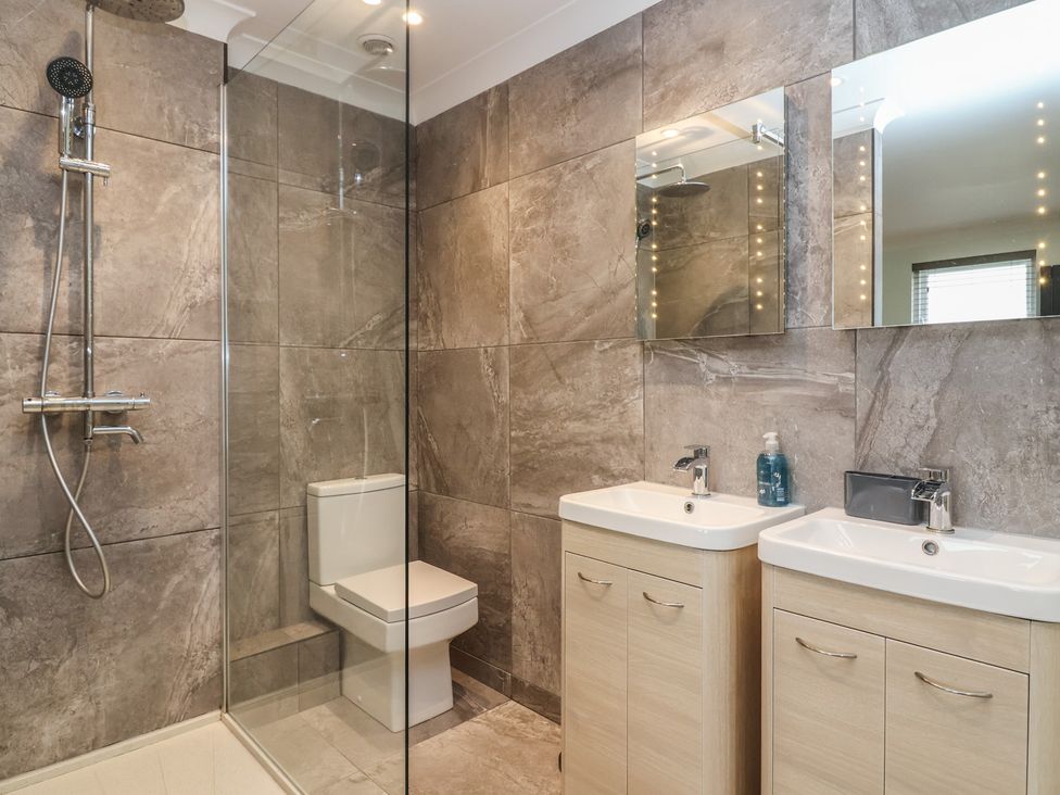 A bathroom with a shower, toilet and sinks at 122 Longridge Way Weston-Super-Mare