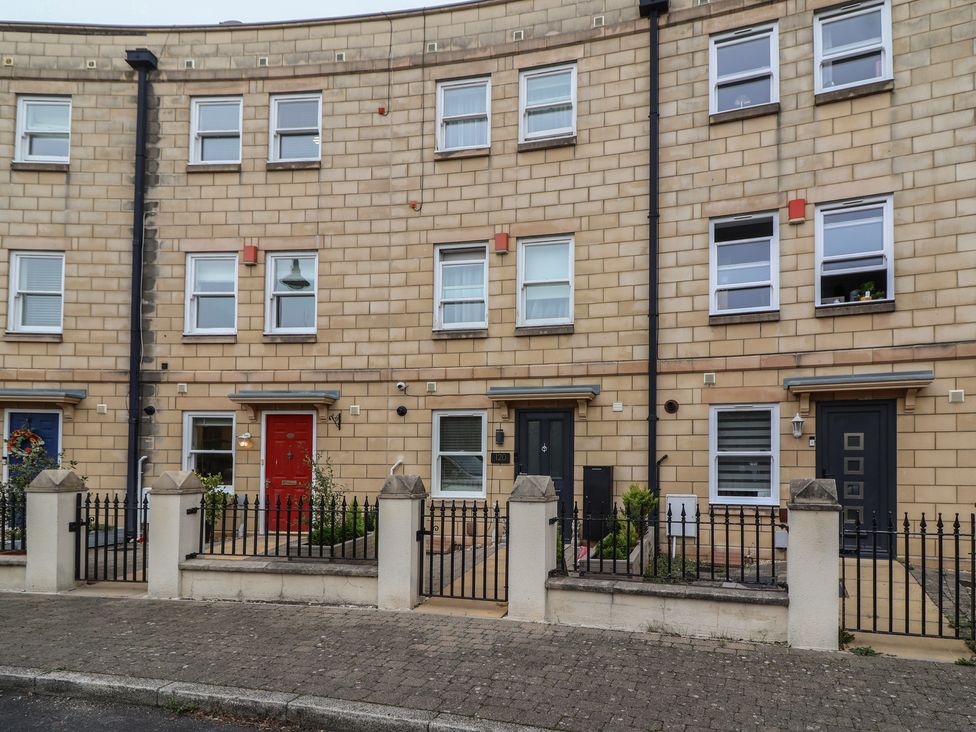 A row of townhouses with different colored doors at 122 Longridge Way Weston-Super-Mare