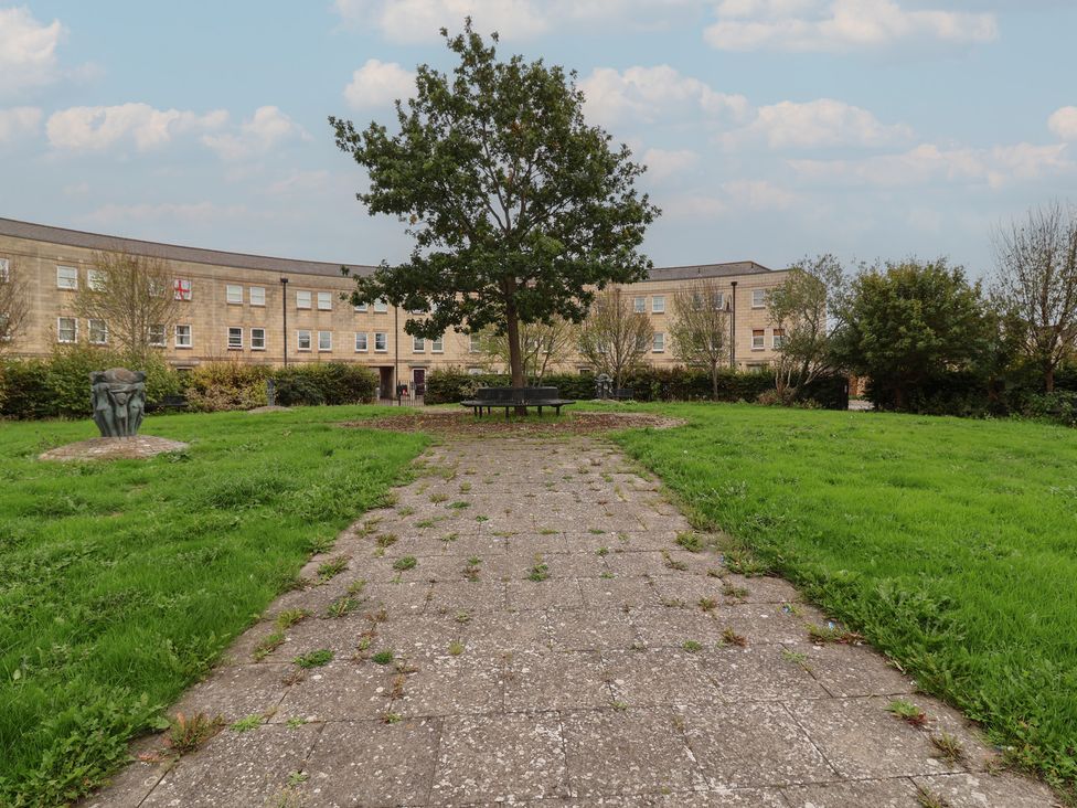 An outdoor area with a tree and benches at 122 Longridge Way Weston-Super-Mare