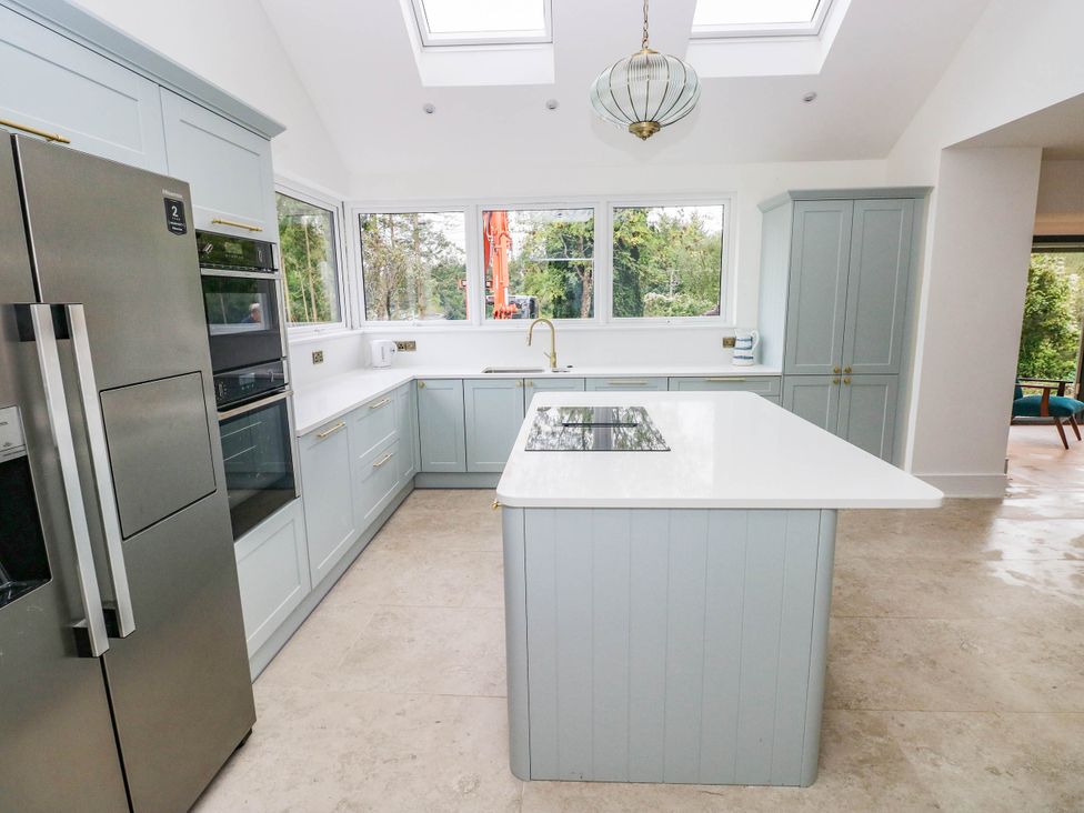 A kitchen with appliances and windows at Hawthorns 