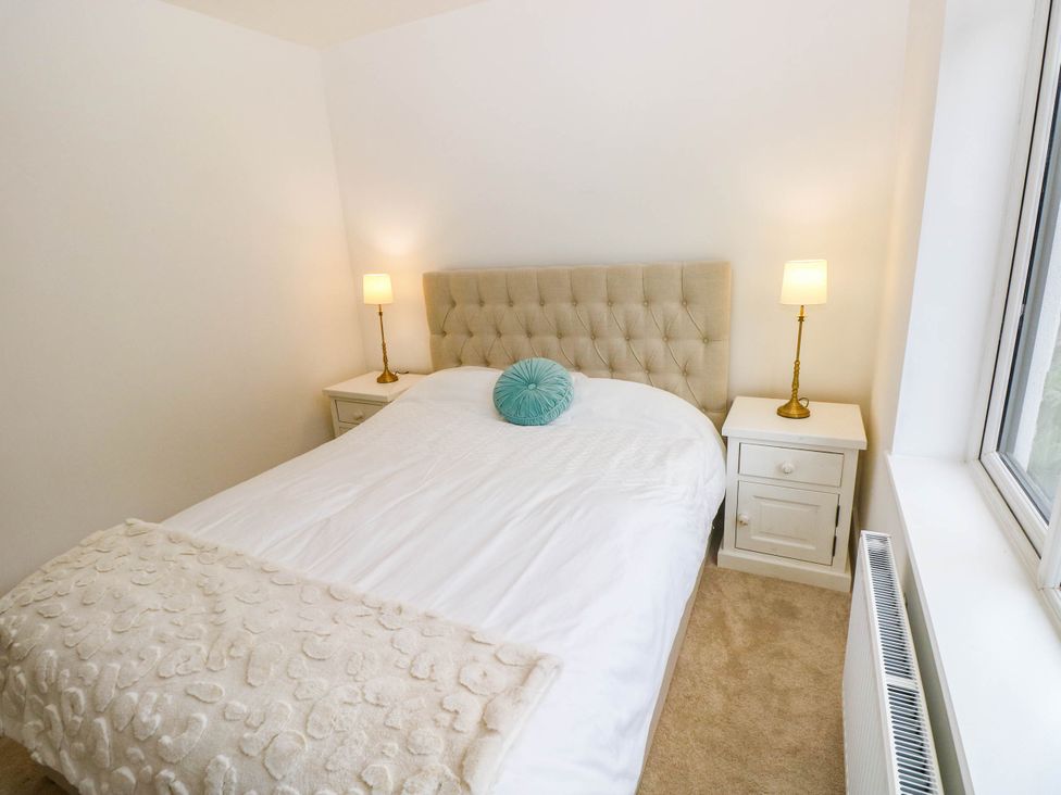 A bedroom with a bed and bedside tables at Hawthorns