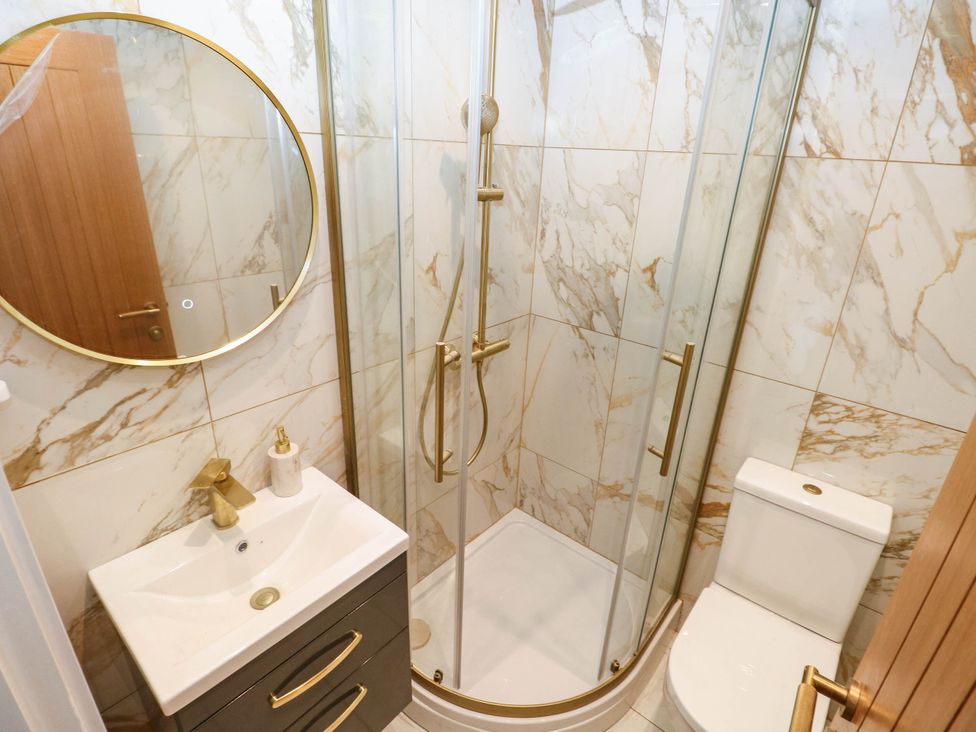 A bathroom with a shower, sink, and toilet at Hawthorns