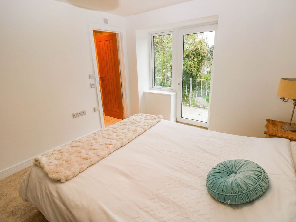 A bedroom with a bed and windows at Hawthorns