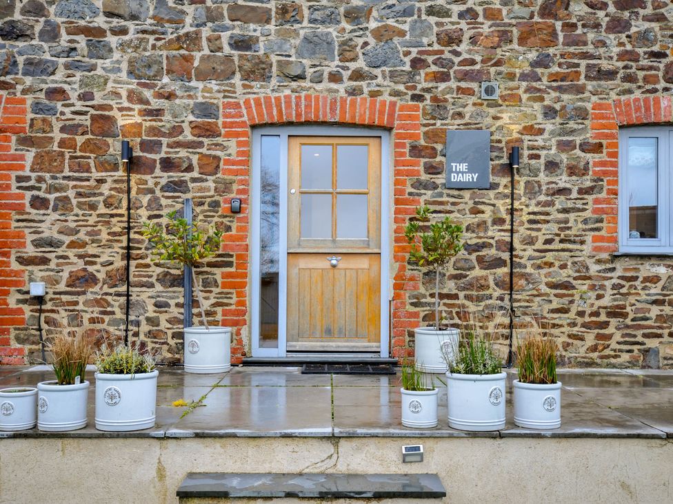 An entrance with a door and plant pots at The Dairy