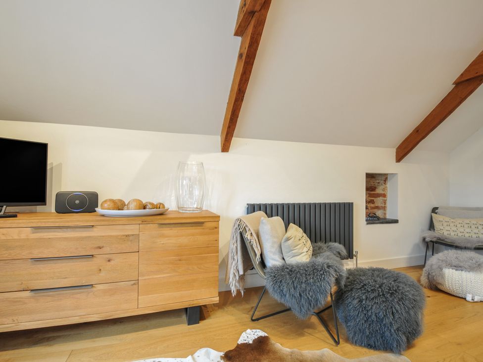 A living room with a television, speaker and wooden dresser at The Dairy in 
